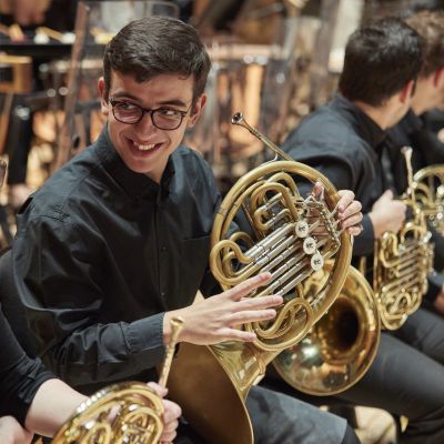 Horn players chatting during a rehearsal